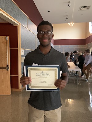 Mich Boden poses with his Love of Learning Scholarship certificate